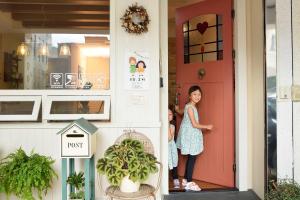dwie małe dziewczynki stojące przy drzwiach domu w obiekcie Good day w mieście Hualian