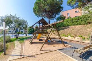un parque infantil con un tobogán y un banco en Boadella - ATICO, en Lloret de Mar