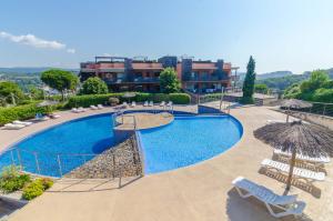 a swimming pool with chairs and umbrellas and a hotel at Boadella - ATICO in Lloret de Mar