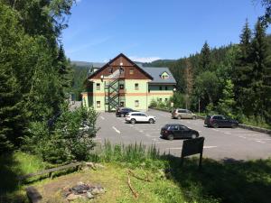 a building with cars parked in a parking lot at Apartmán Orbit in Karlov