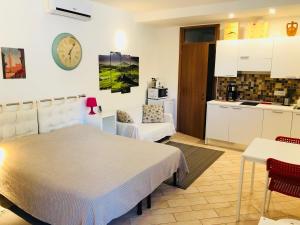 a bedroom with a large bed and a kitchen at La Dolce Vita studio with free private parking in Siena