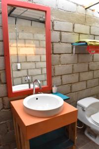 a bathroom sink with a mirror and a toilet at Paraiso Lounge in Santa Marta