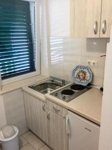 a small kitchen with a sink and a stove at Apartments Pomeštak in Pomena