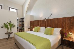 a bedroom with a large bed with a green blanket at Momentum Wellness Bioresort in Marinella di Selinunte