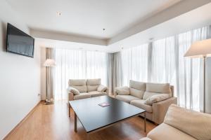 a living room with two chairs and a table at Exe Puerta San Pedro in Lugo