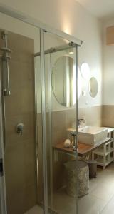 a bathroom with a glass shower and a sink at L'Ulivo in Verona