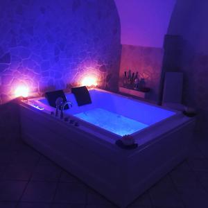 een badkamer met een groot bad met verlichting bij 26 Suite Home in Ostuni