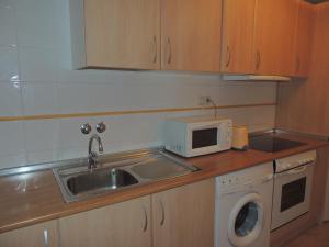 a small kitchen with a sink and a microwave at Apartamento céntrico con WIFI en Biescas in Biescas
