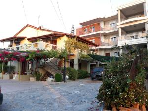 a building with a staircase and flowers in front of it at Eleni Apartment in Pigi +12 photos