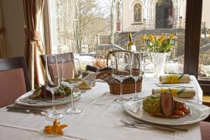 a table with two plates of food and wine glasses at Hotel Richard Spa & Wellness in Mariánské Lázně