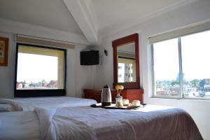 a bedroom with two beds and a table with flowers on it at Hotel Campestre Inn in León