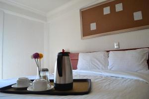 a hotel room with a bed with a tray with coffeeisers at Hotel Campestre Inn in León