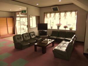 sala de estar con sofás, mesa y TV en Nishimiyasou en Fujikawaguchiko