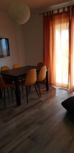 a dining room with a table and chairs and a television at Apartmani Ortolio in Viganj