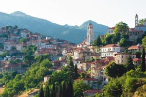 a town on a hill with houses and a clock tower at Ξενώνας questhouse Electra isari in Isaris