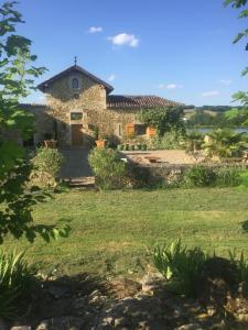 una casa de piedra en medio de un patio en Gîte Le Cézan, en Jégun