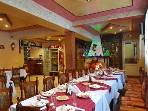 a dining room with long tables with plates of food at Къща за гости "Орлец" in Popovo