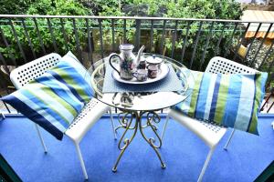 d'une table, de chaises et d'un service à thé sur le balcon. dans l'établissement Il Gelsomino Amalfi, à Amalfi