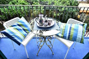 una mesa y sillas con un set de té en el balcón en Il Gelsomino Amalfi, en Amalfi