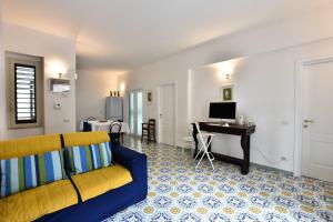 - un salon avec un canapé jaune et un bureau dans l'établissement Il Gelsomino Amalfi, à Amalfi