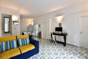 sala de estar con sofá amarillo y escritorio en Il Gelsomino Amalfi, en Amalfi