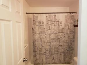 a bathroom with a shower curtain of a city at Blue Penthouse in the City in Atlanta