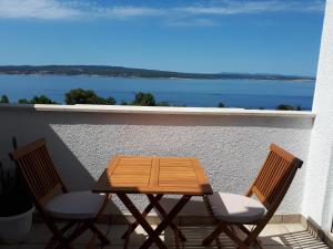 a wooden table and two chairs on a balcony at Apartment Hana in Crikvenica