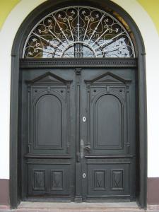 a black door with a wrought iron gate at Nitt Pince és Panzió in Kisharsány