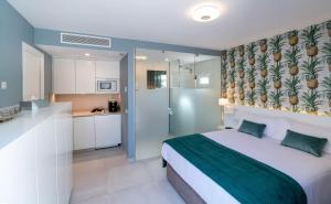 a bedroom with a large bed and a kitchen at Villa RG Boutique Hotel - Adults Only in Playa del Ingles