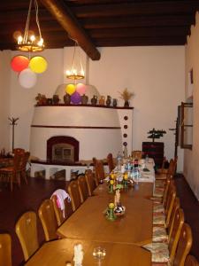 a dining room with a long table and a fireplace at Nitt Pince és Panzió in Kisharsány