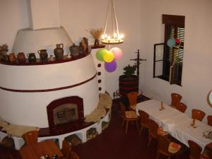a room with a fireplace and a table and chairs at Nitt Pince és Panzió in Kisharsány