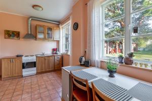 a kitchen with orange walls and a table with chairs at Oitme Hostel in Oitme