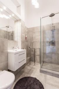 La salle de bains est pourvue d'une douche, d'un lavabo et de toilettes. dans l'établissement Latte Apartment, à Varsovie