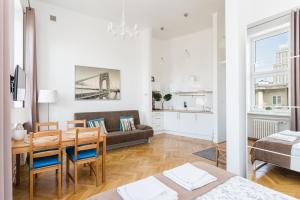 sala de estar con mesa y sofá en Latte Apartment, en Varsovia