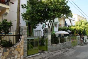 una cerca frente a un edificio con un árbol en Maria & Kyros House, en Parga