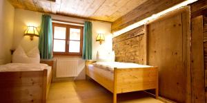 a bedroom with two beds and a window with green curtains at Haus Bergfelder in Hirschegg