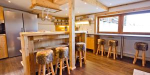 a kitchen with a counter with stools around it at Haus Bergfelder in Hirschegg