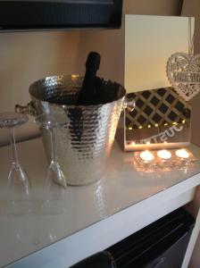 a metal bucket on a counter with candles and a clock at The Coach House in Hawarden