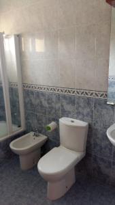 a bathroom with a toilet and a sink at Chalet "El Bosque" 5 habitaciones in Nueva de Llanes +37 photos