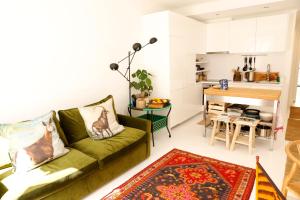 a living room with a green couch and a kitchen at Swimming pool Apartment Central Lisbon in Lisbon