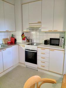 a kitchen with white cabinets and a white stove top oven at Apartment Mikkelissä, Silvasti in Mikkeli
