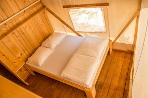 a bed sitting in a room next to a window at Sunflower Camping in Novigrad Istria