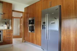 パレーデス・デ・コウラにあるCasa de Coyraの- キッチン(ステンレス製の冷蔵庫、木製キャビネット付)