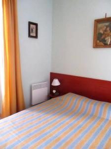 ニースにあるAppartement Narcisseのベッドルーム1室(青と黄色のストライプ毛布付きのベッド1台付)