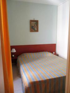ニースにあるAppartement Narcisseのベッドルーム1室(ストライプ毛布付きのベッド1台付)