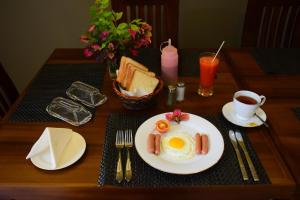 a table with a plate of eggs and toast and coffee at Hill Roost in Kandy
