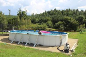 a woman sitting in a hot tub in a field at Wypoczynek Kocia Góra in Dziemiany