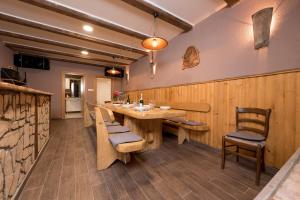 um restaurante com uma grande mesa de madeira e cadeiras em Apartman Sigurnjak em Matulji