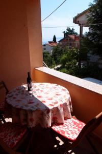 - une table sur un balcon avec une bouteille de vin dans l'établissement Villa Lina, à Ičići