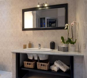 a bathroom with a sink and a mirror and towels at La Casa nel Corso in Cagliari